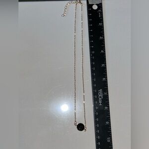 gold necklace featuring a striking black crystal